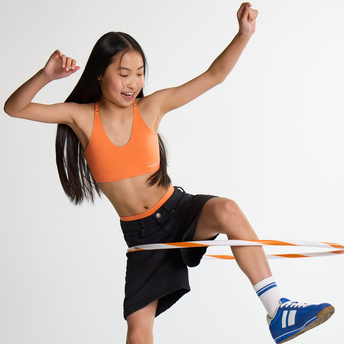 Girl wearing MeBeBodee branded orange v-neck sports bra
