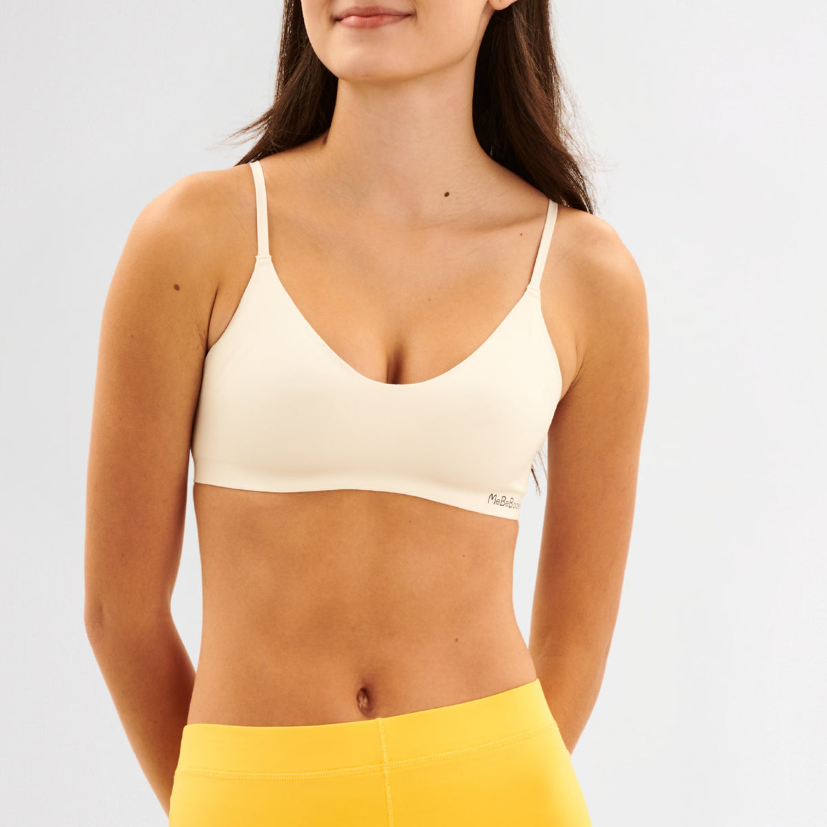 Teen Girl wearing a white bra and yellow leggings on a light gray background