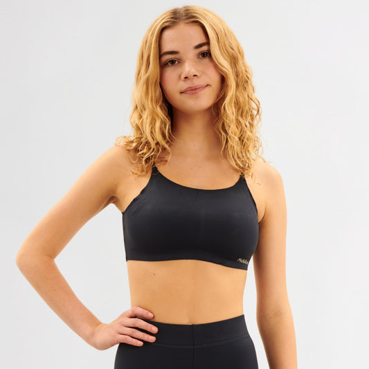 Youth wearing a navy sports bra and leggings on a light gray background