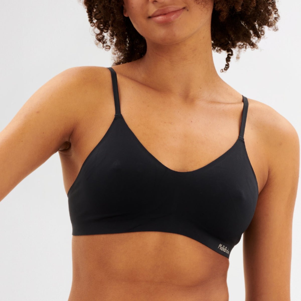 Teen Girl wearing a navy coloured bra with a visible brand 'MeBeBodee' logo on a plain background